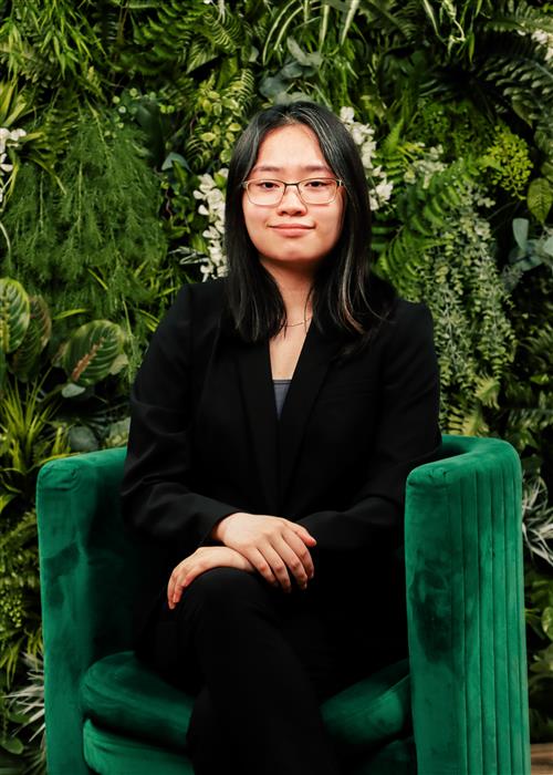 Teenage girl wearing black sitting in a green chair